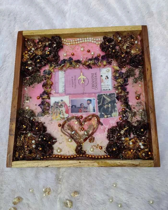 Decorative shadow box with pink background, decorative elements, and a heart shape.