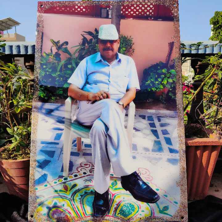Man sitting on a chair with a colorful frame in an outdoor setting