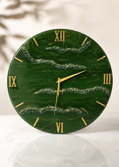 Green marble clock with gold Roman numerals on a white surface
