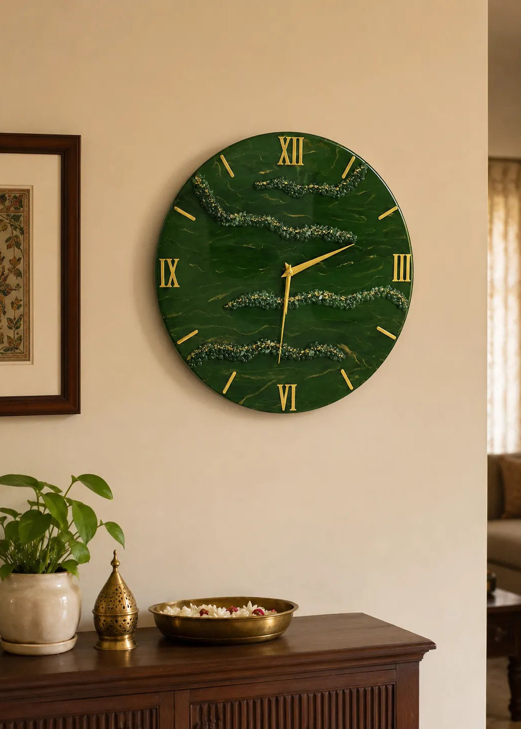 Green wall clock with gold accents on a beige wall, next to a wooden cabinet with decorative items.