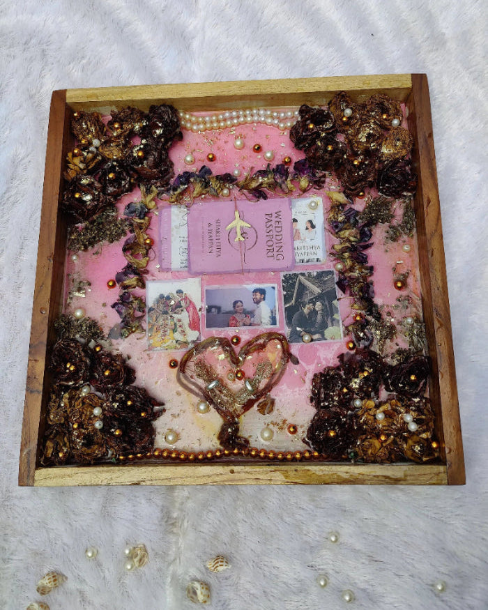 Decorative shadow box with pink background, decorative elements, and a heart shape.